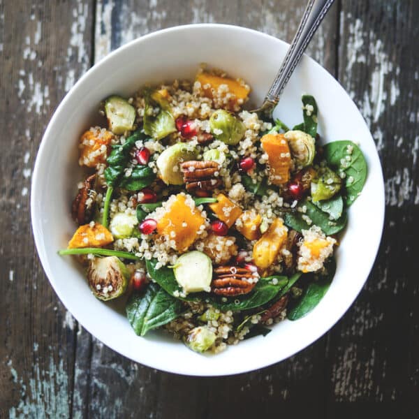 Winterlicher Rosenkohl-Salat mit Granatapfelkernen, Feta und gerösteten Mandelsplittern, serviert in einer Schüssel